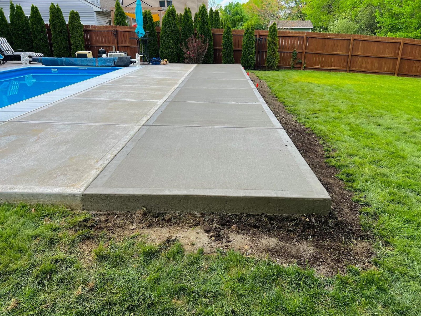 Concrete patio extension for outdoor dining and a grill