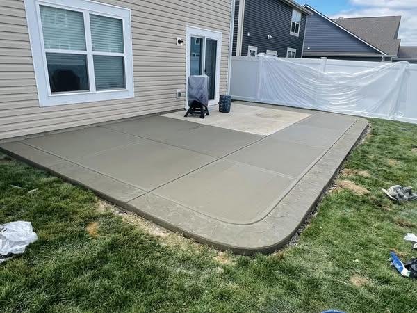 Broom-finished backyard concrete patio with a picture-frame border