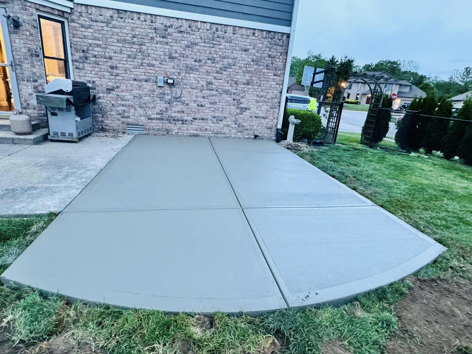 Concrete patio extension for outdoor dining and a grill