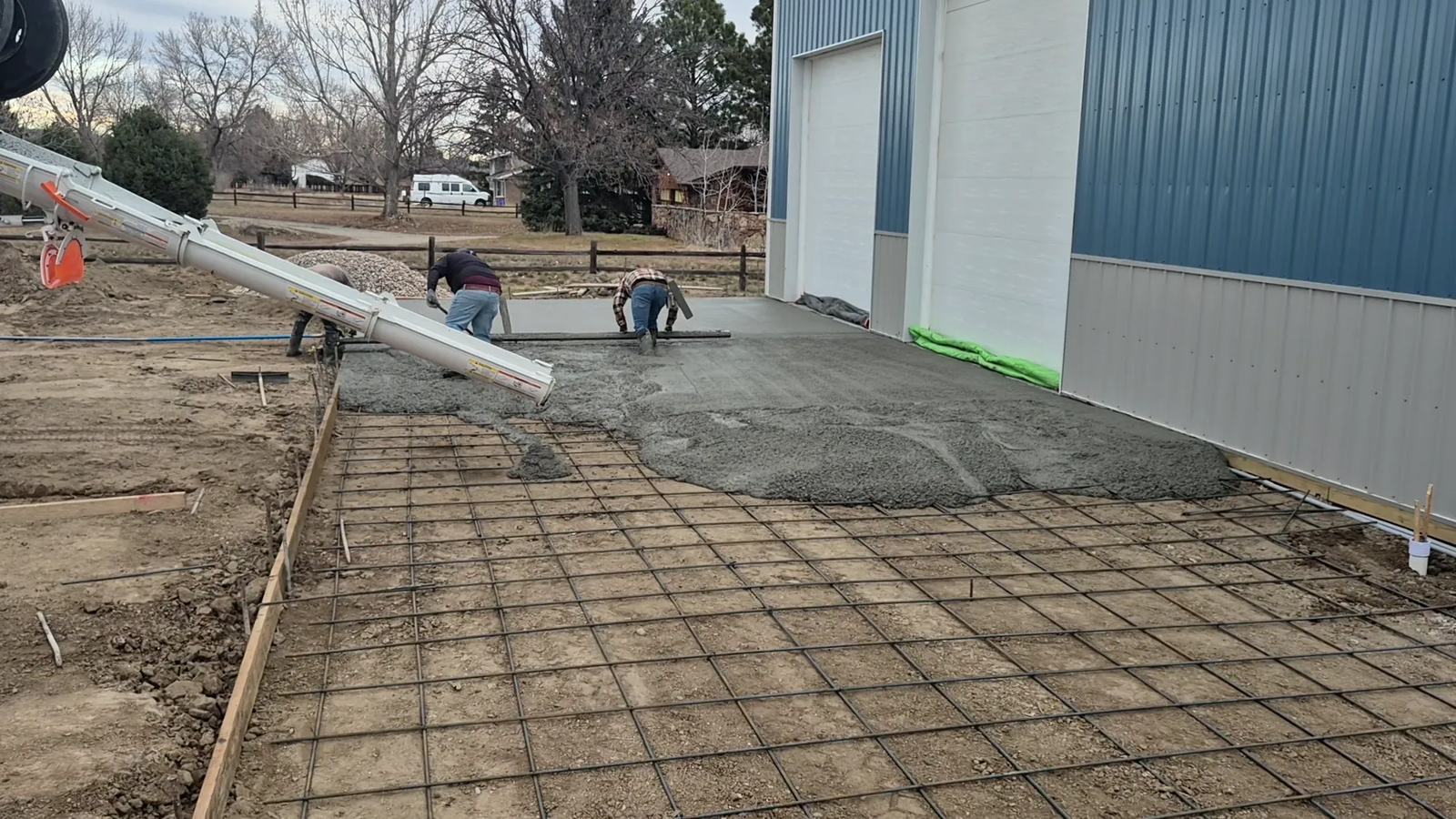 Freshly poured residential concrete driveway receiving a broom finish in Indianapolis